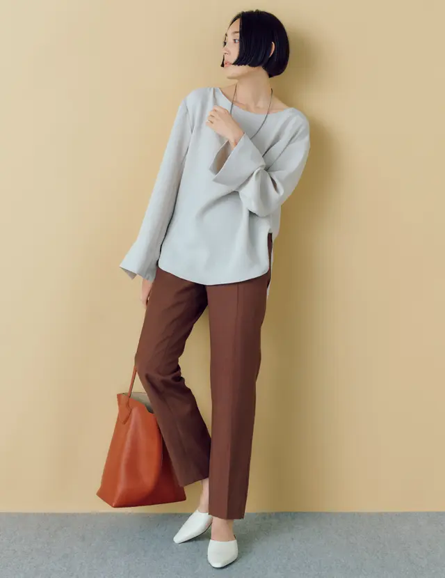 くすんだブラウン系の渋色パンツに、トープ色のとろみブラウスをコーデした優しげなムードのLIZA