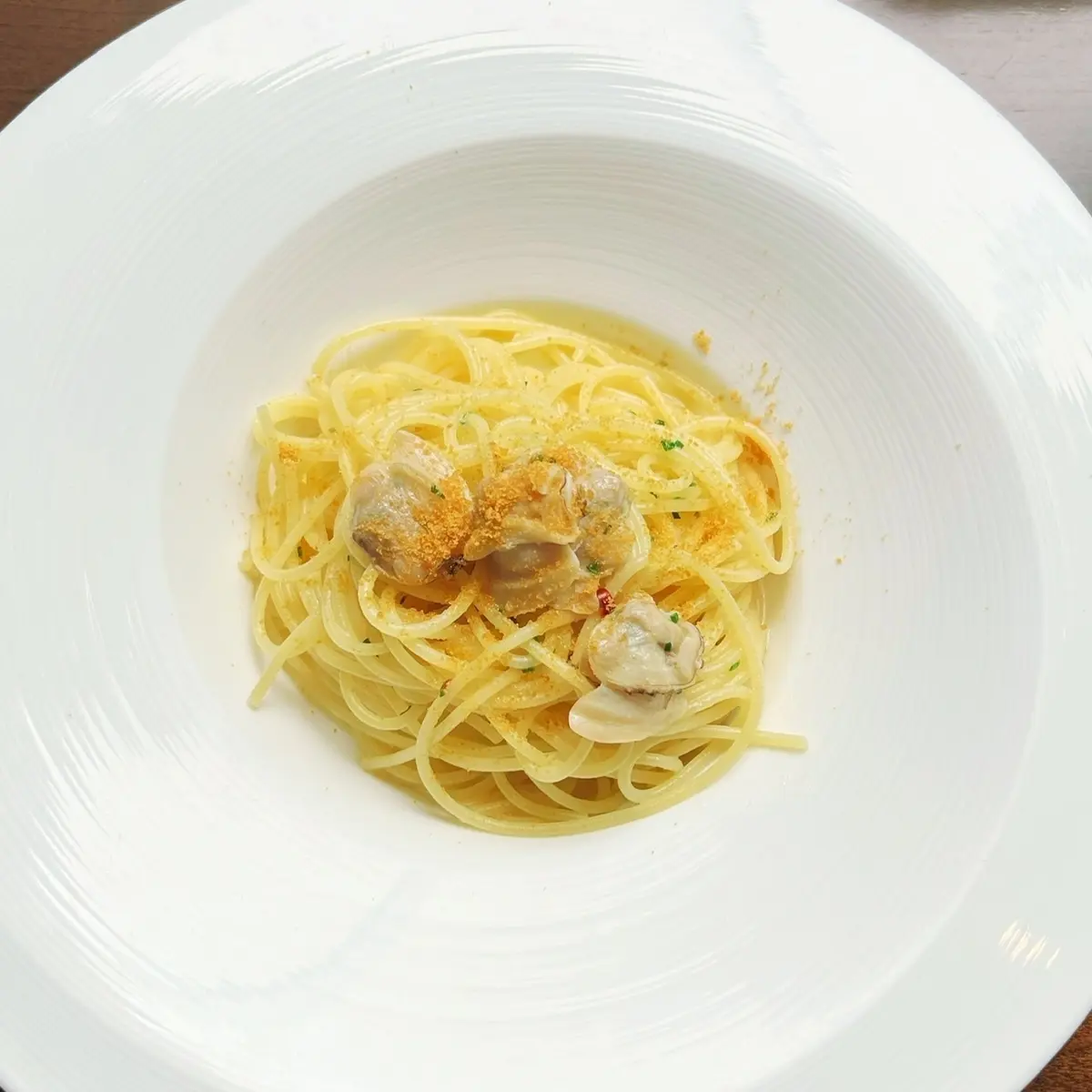 一品目はカラスミがふりかけられた蛤のオイルベースパスタ。