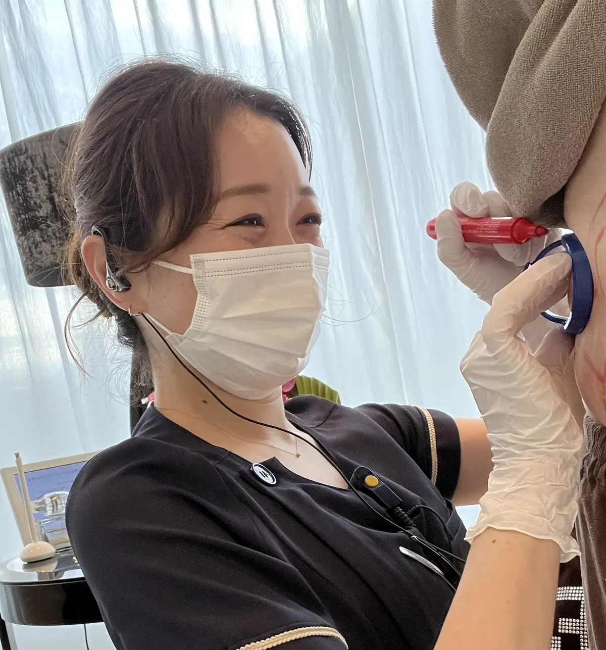 アプリケーターの位置を決めるスタッフ