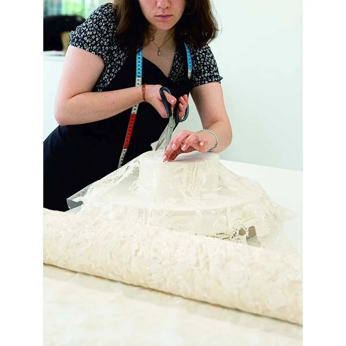 モディストの仕事の中でも、形にな ったフェルトにレースやツイードをはる作業は最もむずかしく、熟練を要する