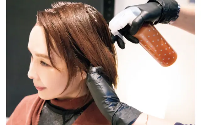 カラーリングの前に、ダメージ予防の処理剤を髪全体に塗布