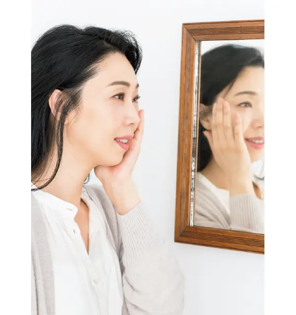 鏡を見ながらスキンケアをする水井真理子