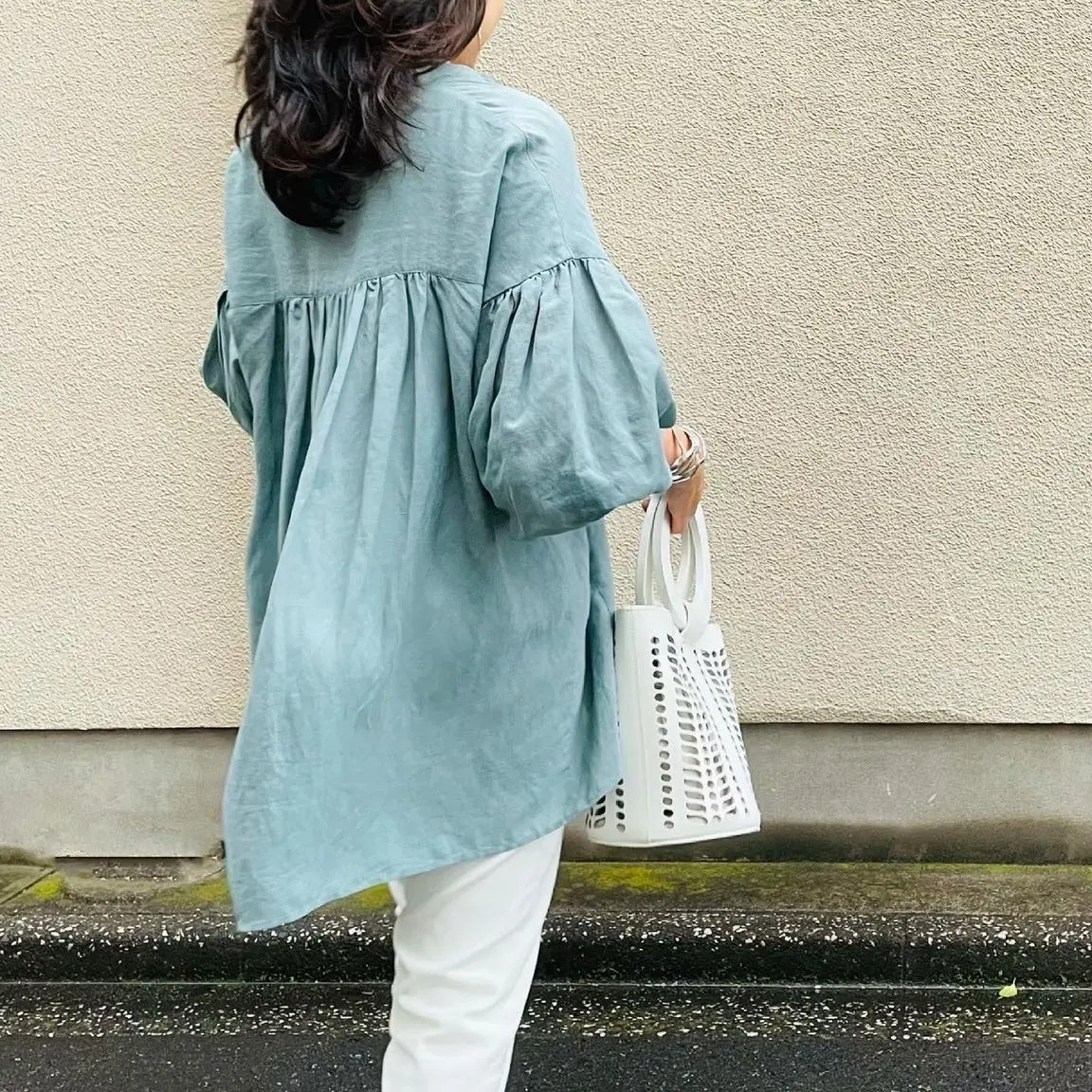 ブルーのスキッパーブラウス、白パンツ、白バッグのコーディネート後ろ姿