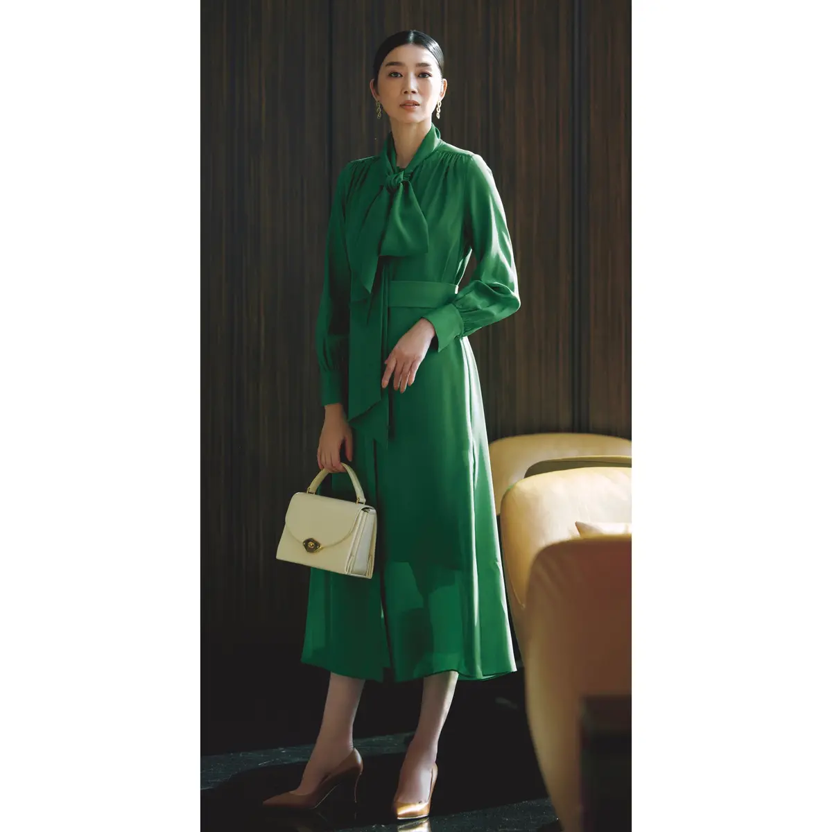 グリーンボウタイつきワンピースに白ハンドバッグを合わせたコーディネート　モデル・ゆうき