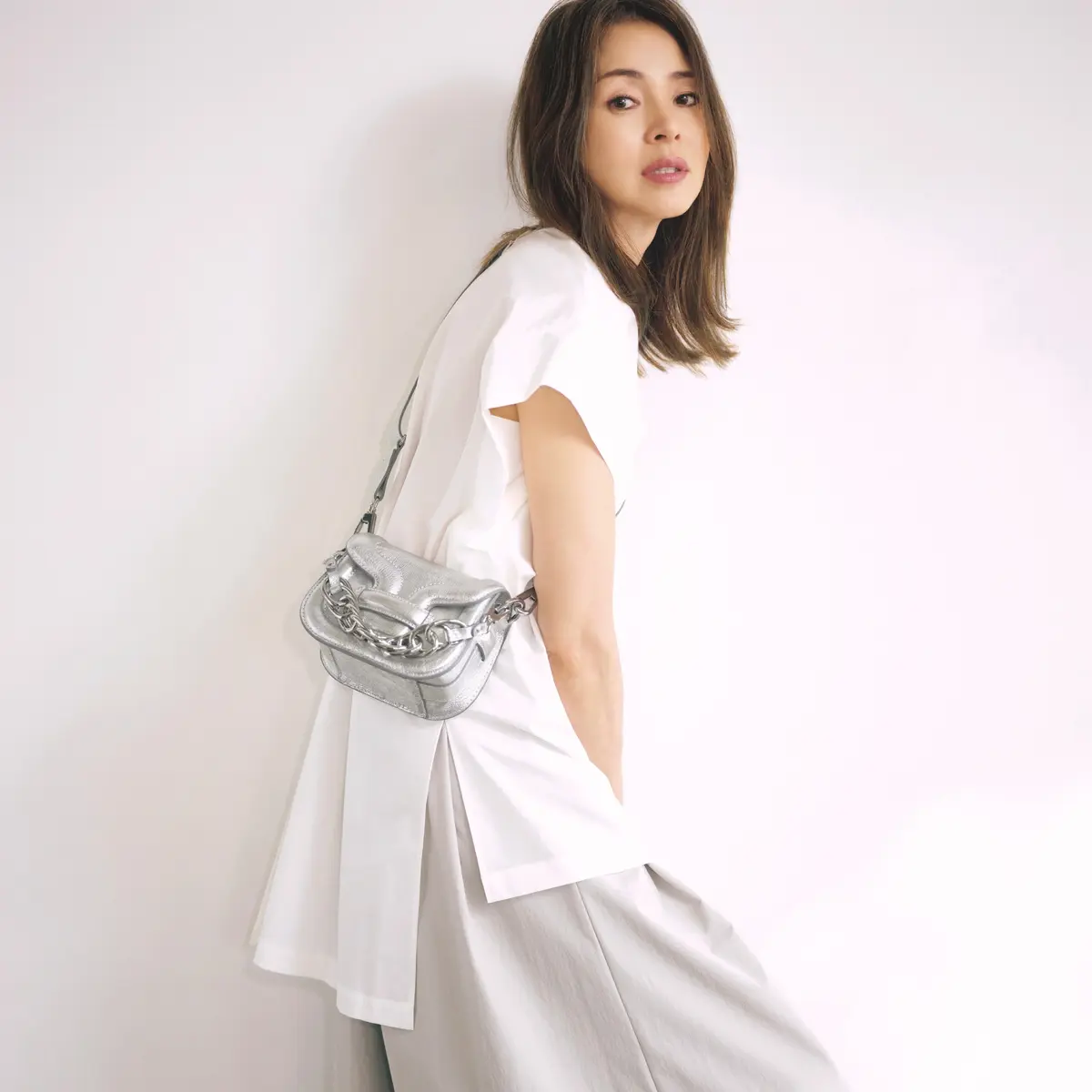 白Tシャツにライトグレーワイドパンツを合わせ、シルバーミニバッグを持ったコーディネート　モデル・SHIHO