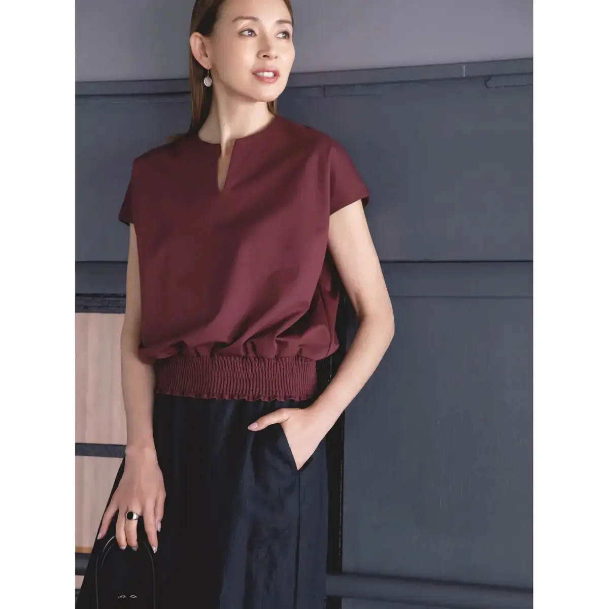 ボルドーカラーのトップスで軽やかなワンツーコーデに深みを与える。