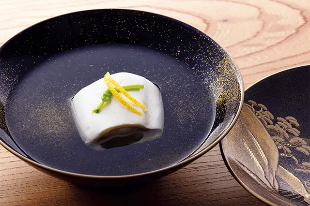 豆腐をかまくらに見立て、甘鯛 を豆腐で覆い、蒸し上げた椀物。 ぐじのかまくら蒸し