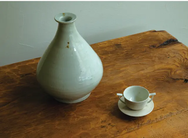 薪窯ゆえの黒点の表情が美しいホン氏の白磁。カップは耳盃と呼ばれる骨董の杯をヒントに。壺W500,000、カップW150,000、ソーサーW40,000