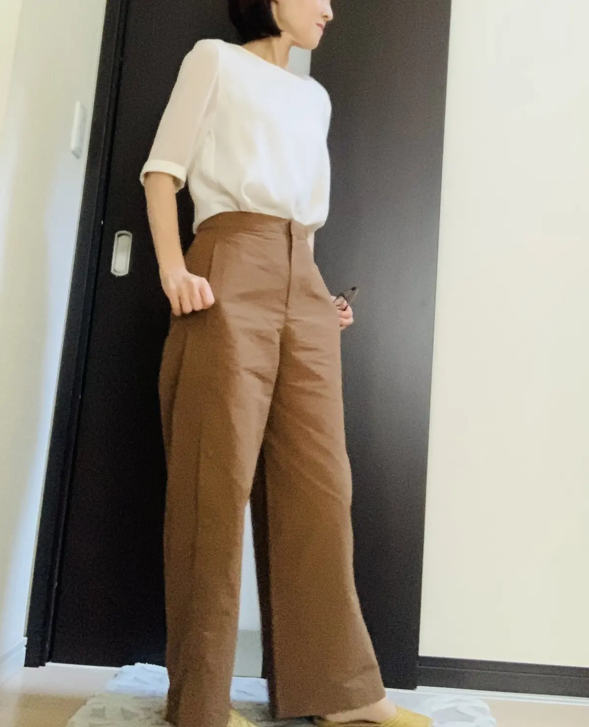 オフホワイトのトップスとブラウンパンツのコーデ