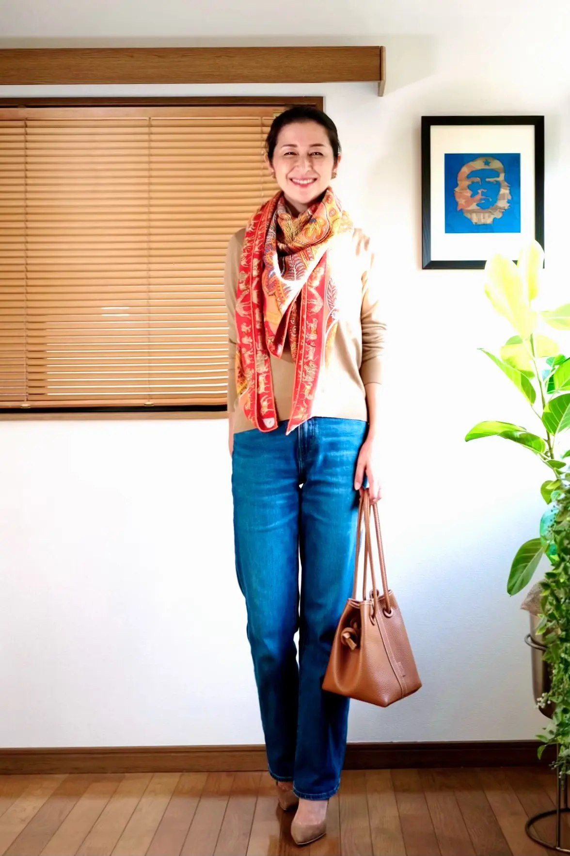 ユニクロベージュニット、ユニクロセミワイドデニム、オレンジ系スカーフ柄ストール、ベージュのパンプス、くすみオレンジのバッグ
