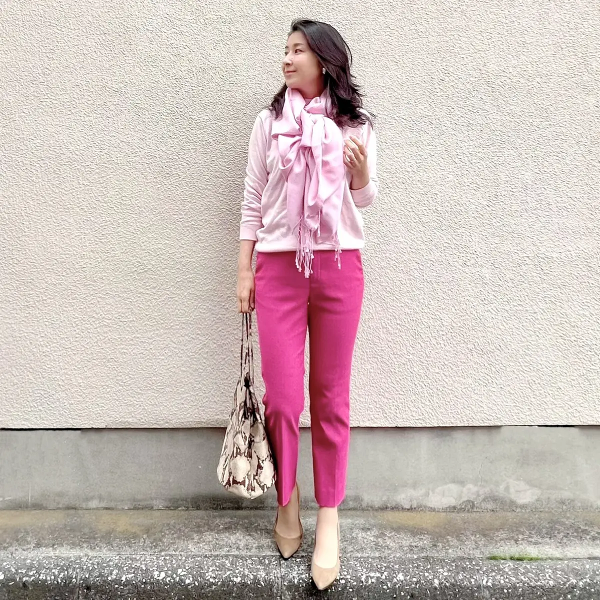 ピンクニット、濃いピンクパンツ、ピンクストール、ベージュのパンプス、ベージュ系パイソンバッグ