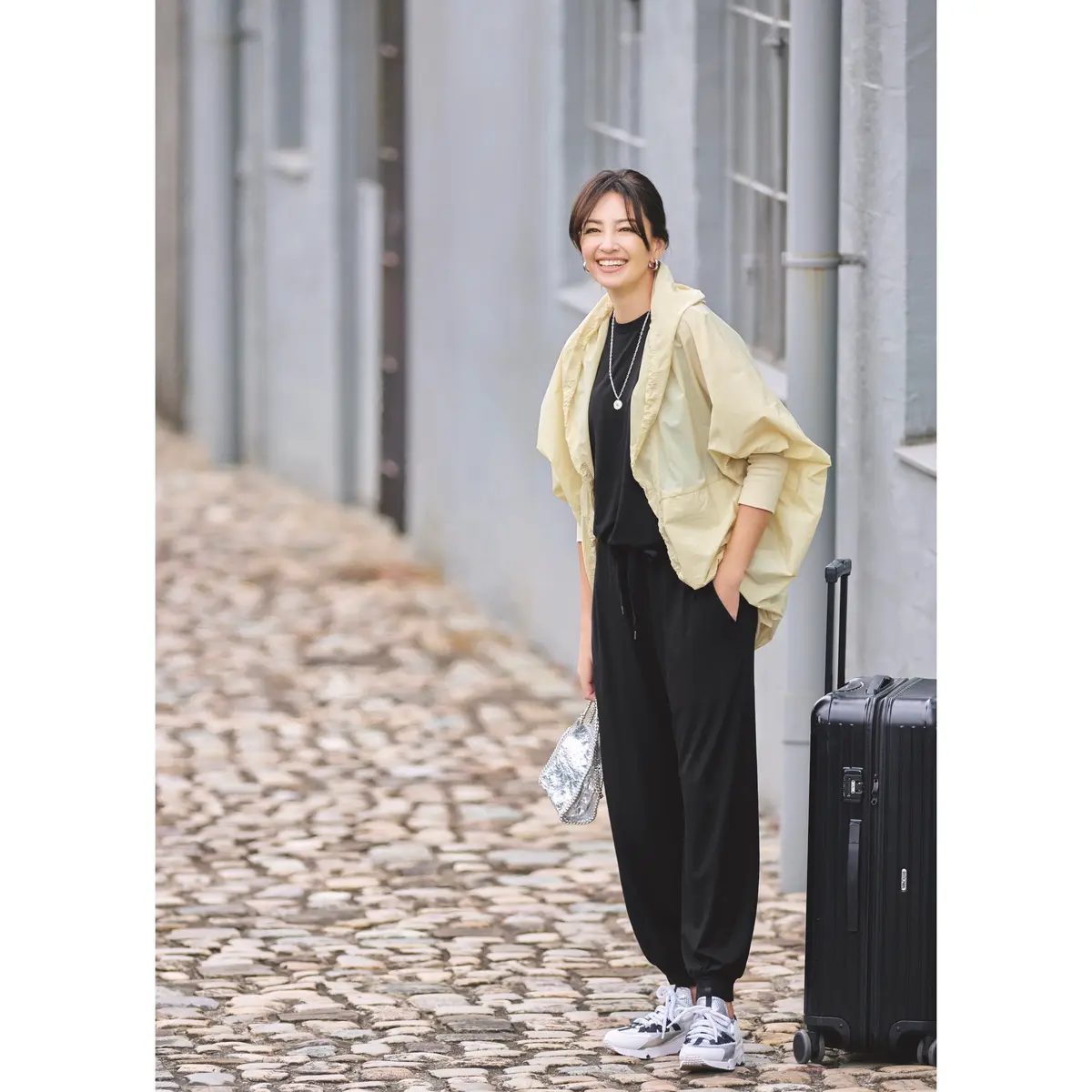 ペールイエローのブルゾンに黒トップスと黒ジョガーパンツのコーディネート　モデル・RINA