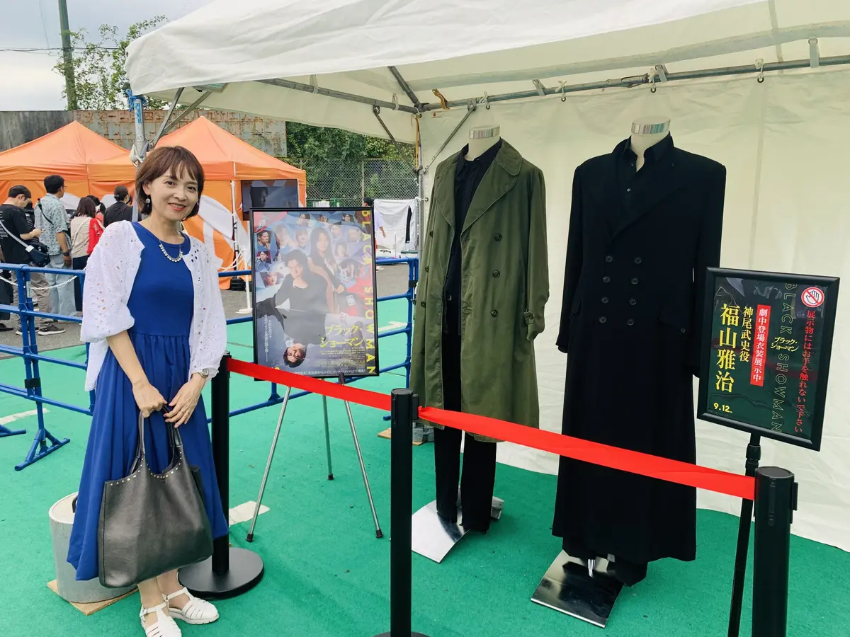 『ブラック・ショーマン』の衣装展示コーナーで写真撮影をする女性