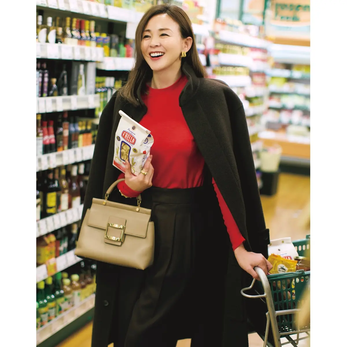 赤クルーネックニットにダークブラウンのタックパンツを合わせ、ダークブラウンのスタンドカラーコートをはおったコーディネート　モデル・SHIHO