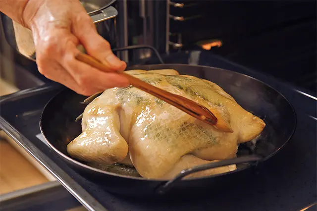 途中で何回か鶏の向きを変えて、溶かし バターを塗りながら焼き上げる。