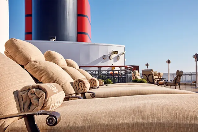 上級クラスであるグリルクラスの乗客専用デッキ。心地よいソファベッドに寝転がって、空と景色を満喫できる。クイーン・エリザベスには、比較的気軽なブリタニアクラスと上級のグリルクラスがあり、選択肢が幅広いのも特徴