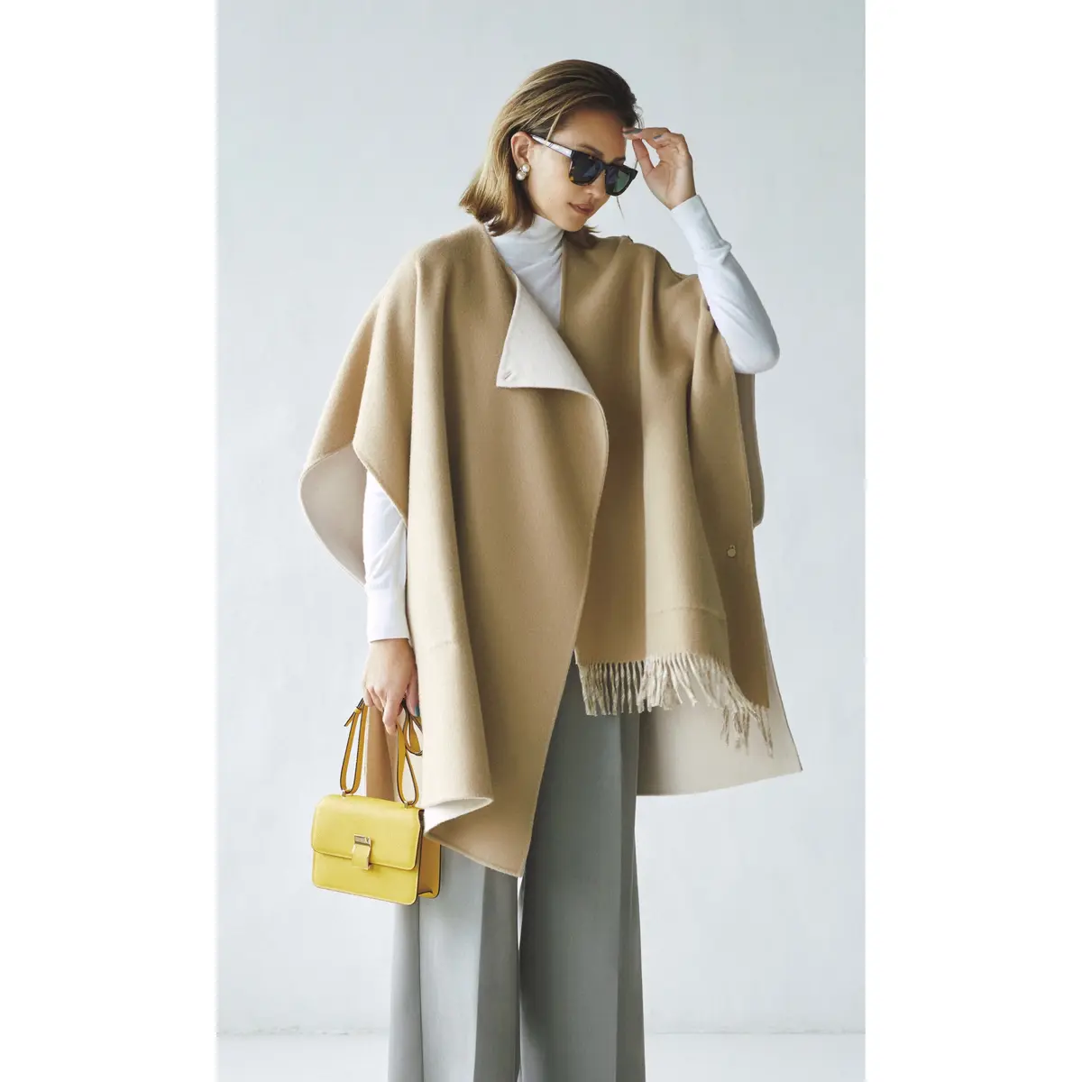 ベージュケープ風アウターとグレーパンツのコーデ　モデル・RINA