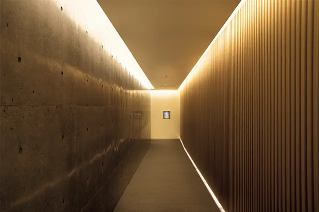 玄関ののれんをくぐると、別世界へと誘いざなわれるような通路が続く、コンクリートを用いた安藤建築