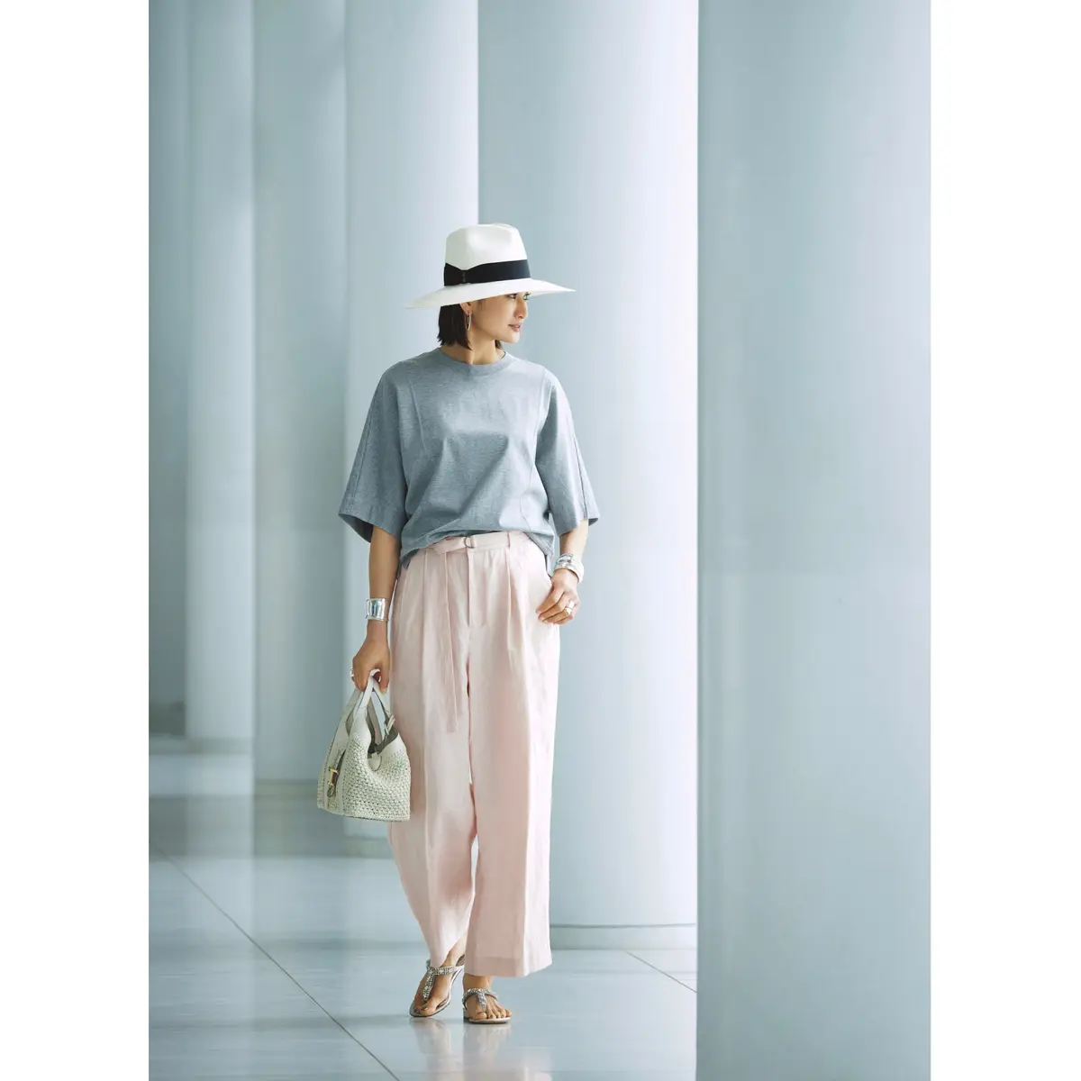 グレーTシャツにペールピンクのワイドパンツを合わせ、白ハットを被ったコーディネート　モデル・渡辺佳子
