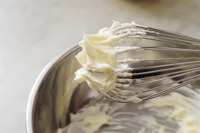 軟らかくしたバターをボウルに入れ、塩を加え泡立て器で空気を含ませるように攪拌（かくはん）する。