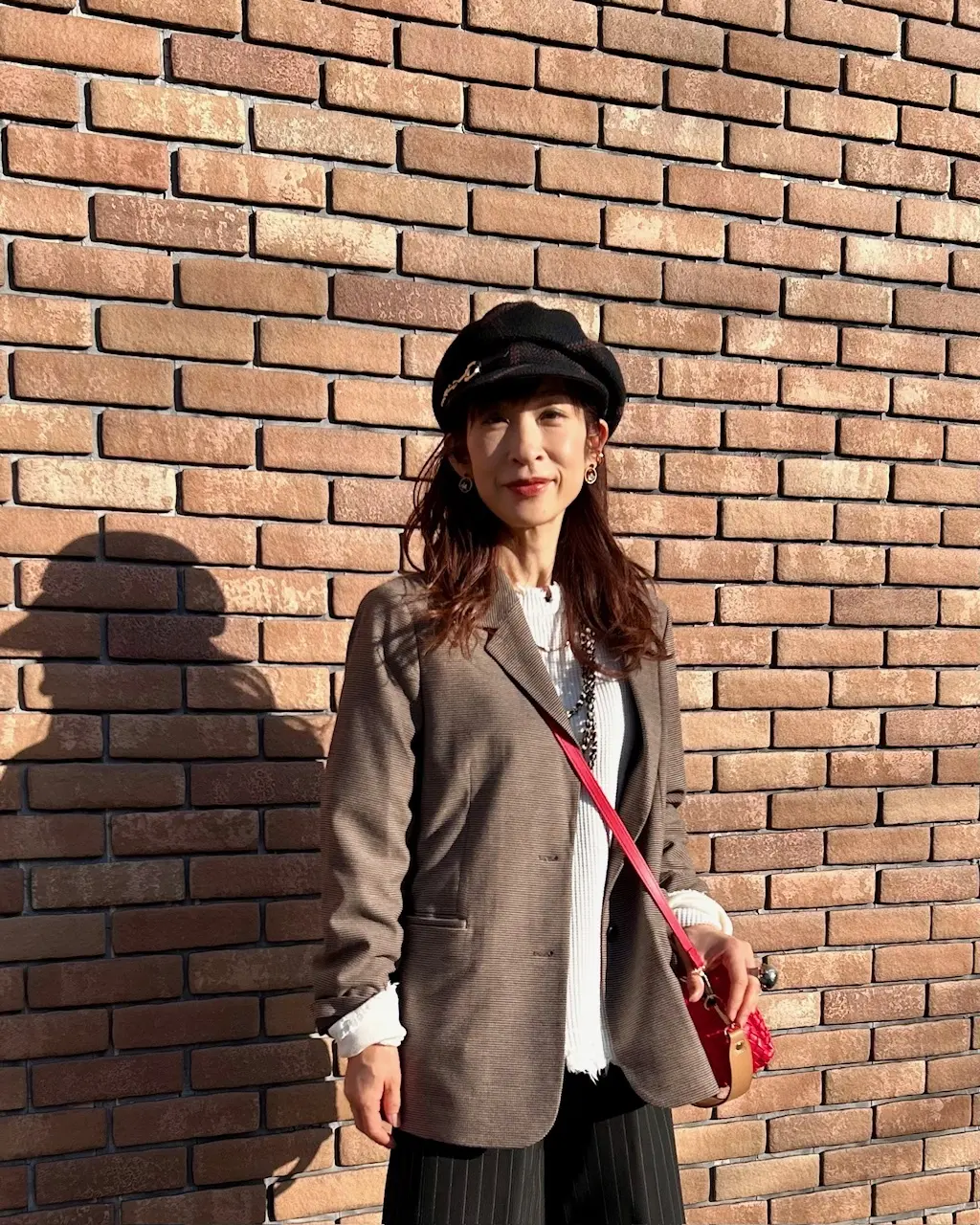 無印良品のブラウンジャケットに赤いバッグの画像_5