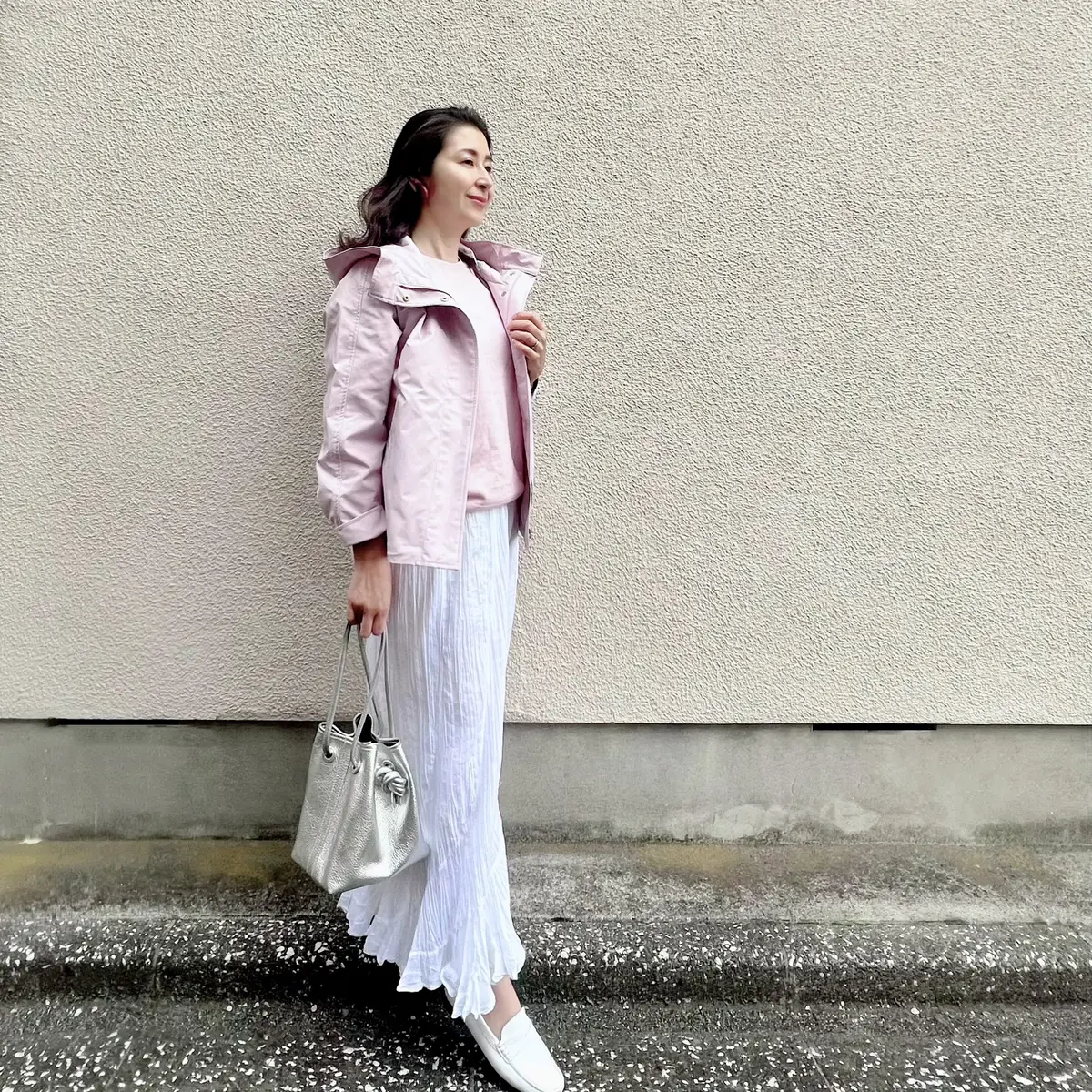 ピンクのマウンテンパーカー　ピンクのニット　白のロングスカート　白のローファー　シルバーのバッグ