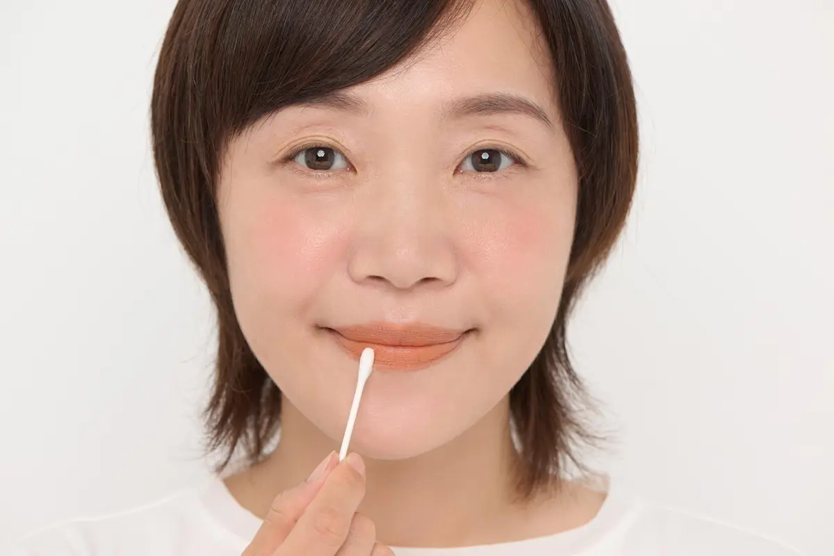 OurAge×Webエクラ リップクリームを綿棒に取り くすみオレンジになじませる