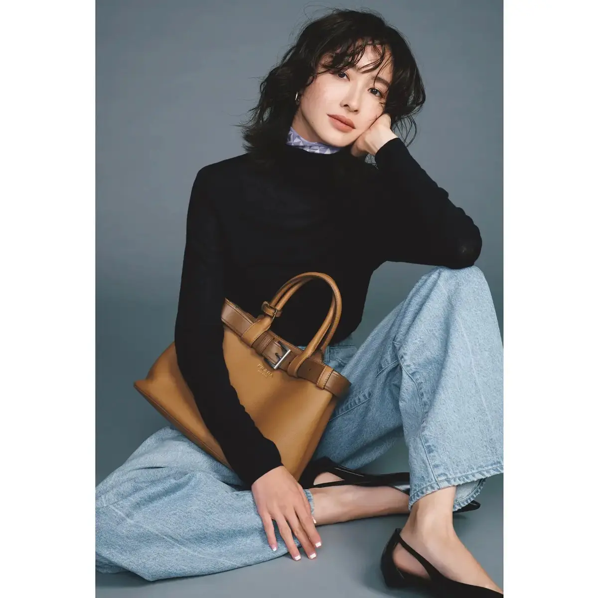 柄スカーフをコンパクトに効かせて、シンプルな黒タートルを鮮度高く着こなす。