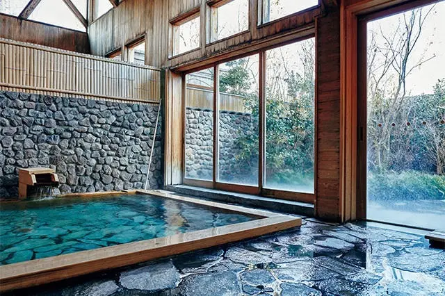 天井が高く広々と開放的な、宿泊者専用の露天風呂つき大浴場。お湯はさらりとした単純泉で、源泉と循環を併用する