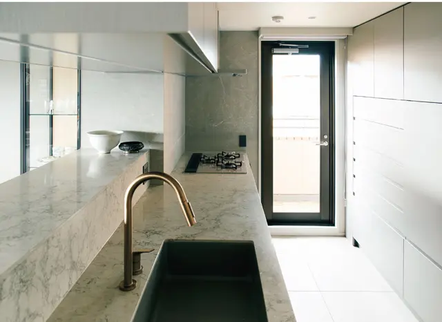 水洗金具はアクサー。グレーのシンクは山田さんの提案。汚れが落ちやすくお手入れがラクで、耐久性の高いCOMOのカラーシンク。コンロとオーブンはリンナイ。愛用の土鍋や鋳物鍋がそのまま使え、オーブンも高温で焼けるガスを選択した