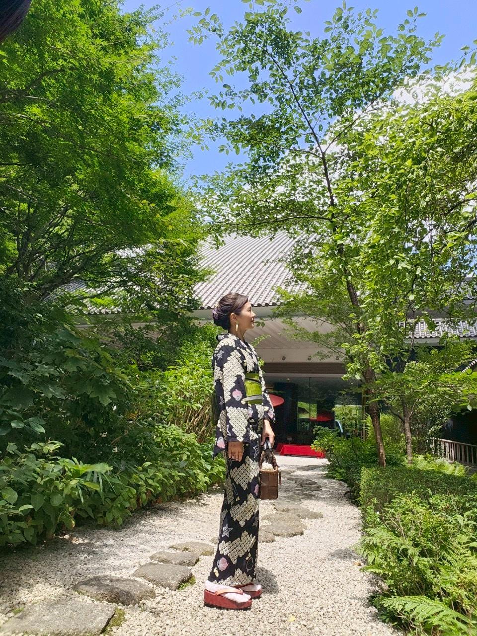 雅叙園中庭に立つ浴衣姿の女性の写真。緑とのコントラストが美しい