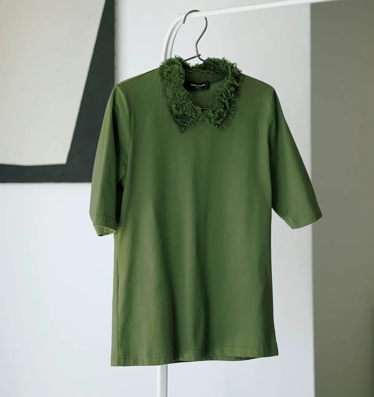 スポーティなポロトップスの襟をフリルで飾り、クチュール感をプラス。ほ どよいコンパクトさも、大人がきちんときれいに着られる理由。ブラウス￥104,500／アオイ（ファビアナフィ リッピ）