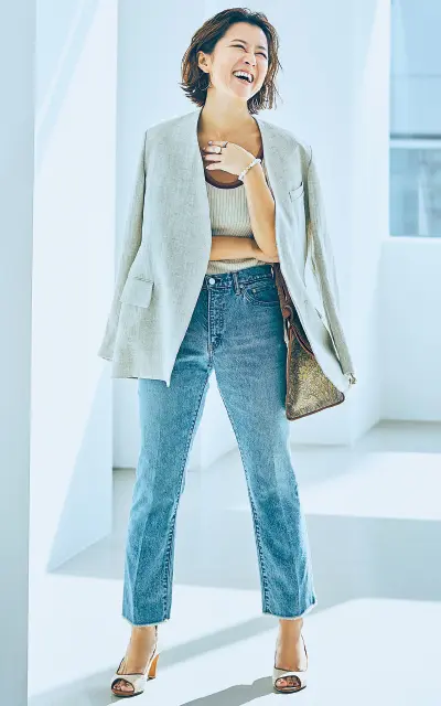 ニットにジャケットを肩がけしたコーデの大草直子