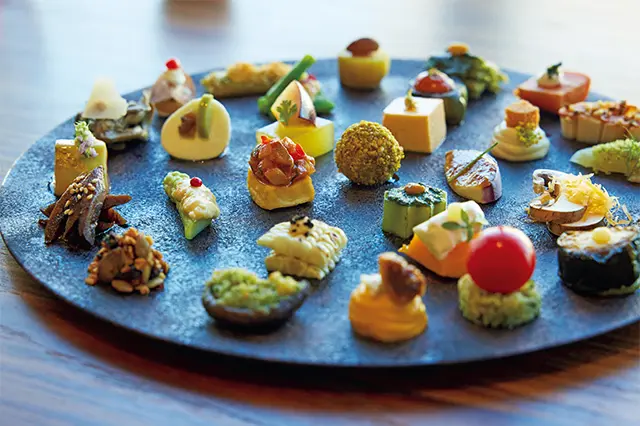 ❶「＂スペシャリテ＂インサラティッシマ・ギフト」。30種の料理名が書かれたメニュ ーの順番どおりに、パズルのように料理を見つけて食べていくのも楽しい。このひ と皿でワインを2杯楽しむゲストが多いとか