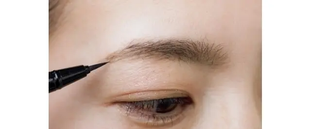 生えていない眉じりも02でぼかしたパウダーの範囲を目安に、リキッドの毛先でスッスッと描き足す。