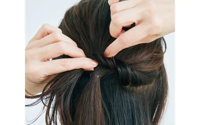 《1》耳より上の髪を斜め下へサイドに寄せて結び、後頭部は部分的に毛束を引き出してくずす。