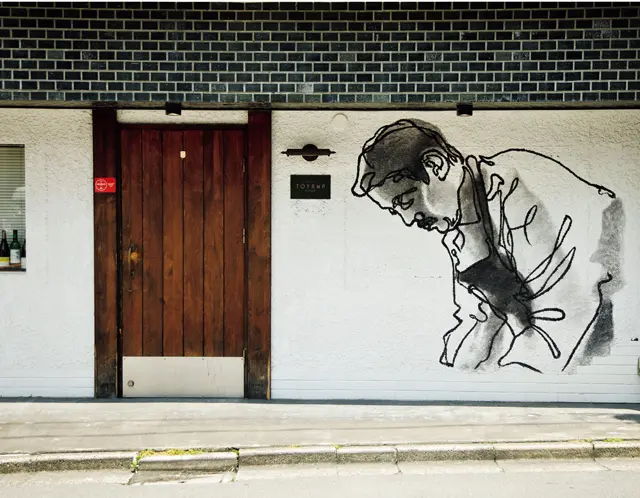 西麻布の交差点のほど近く、シェフの顔が描かれた壁が目印