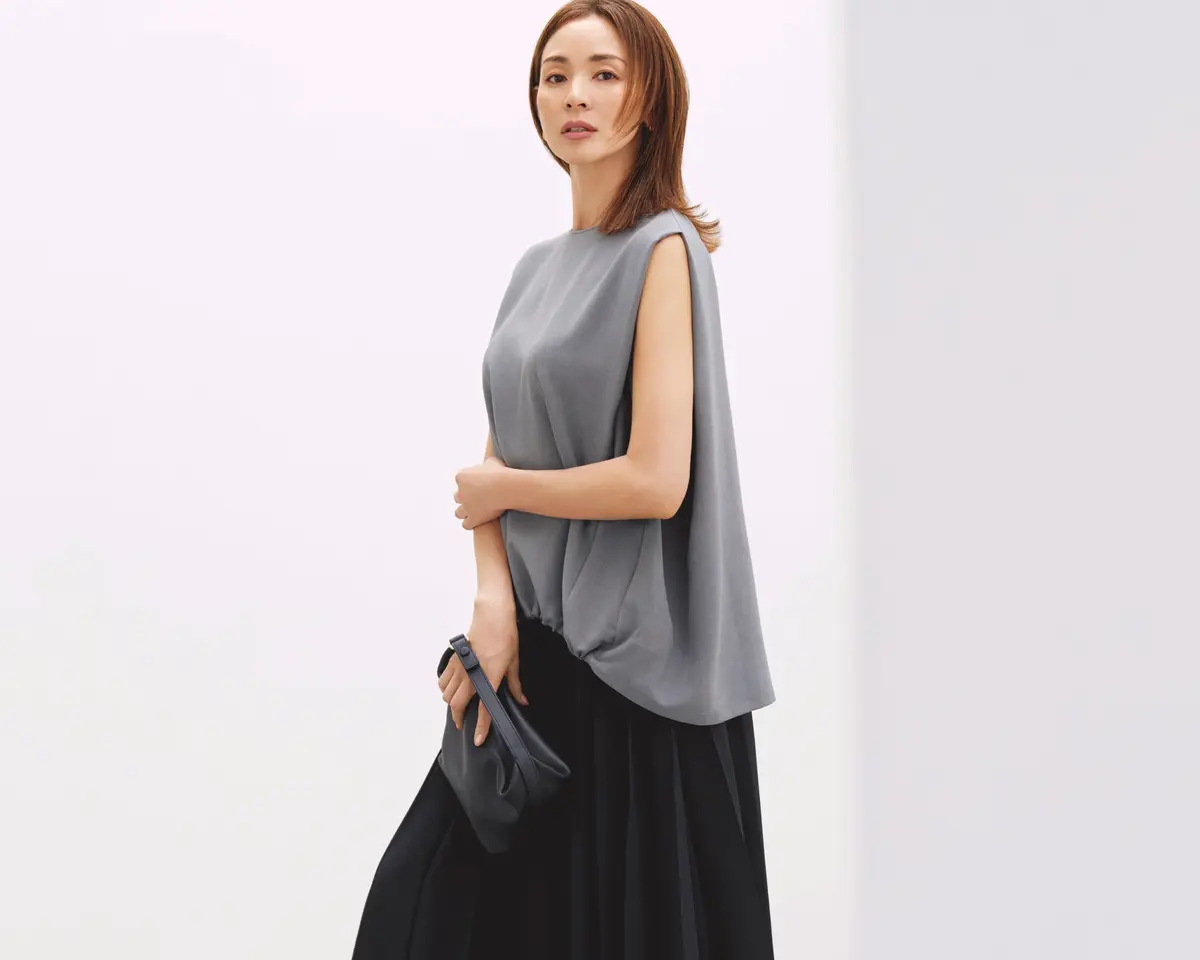 グレーノースリーブトップスに黒ロングスカートを合わせたコーディネート　モデル・SHIHO