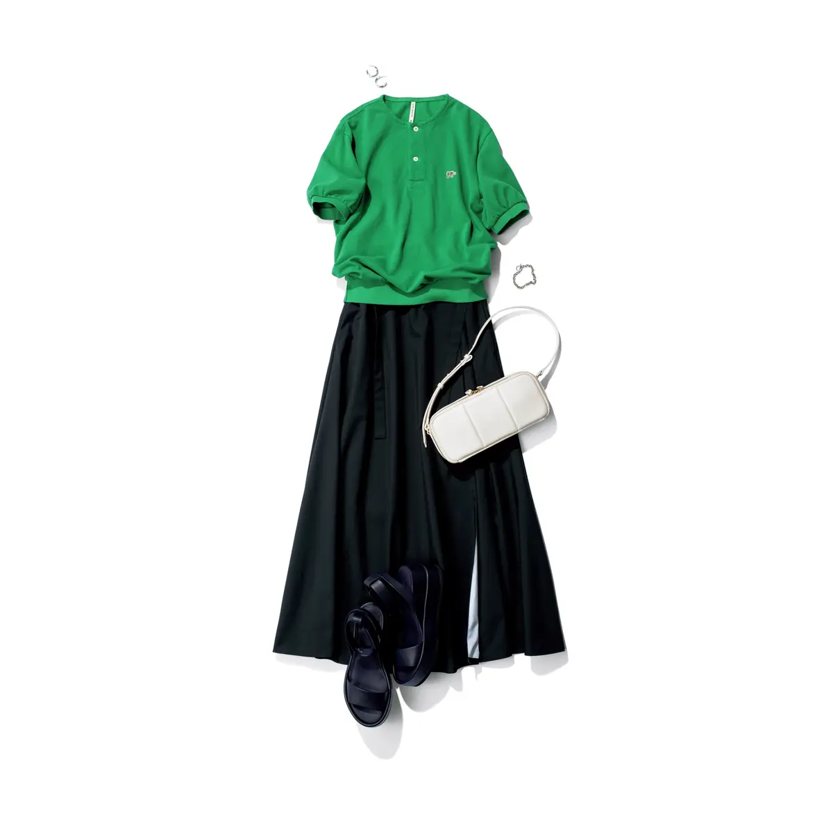 グリーンの丸首ポロシャツに黒ラップスカートのコーディネート　