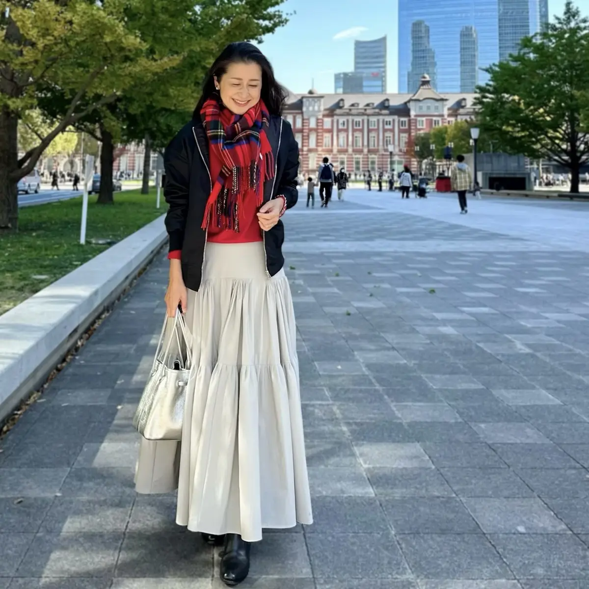 グレーロングスカート、赤ニット、赤のチェック柄ストール、黒MA-1、黒ブーツ、シルバーのバッグ