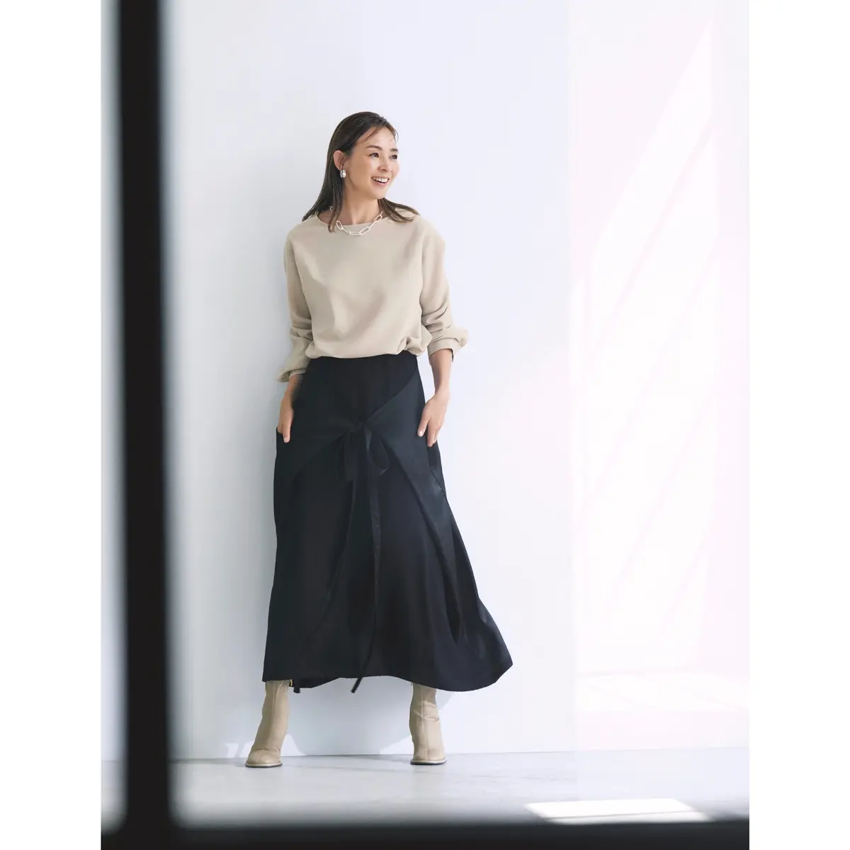 ベージュトップスに黒ラップデザインスカートを合わせたコーディネート　モデル・SHIHO