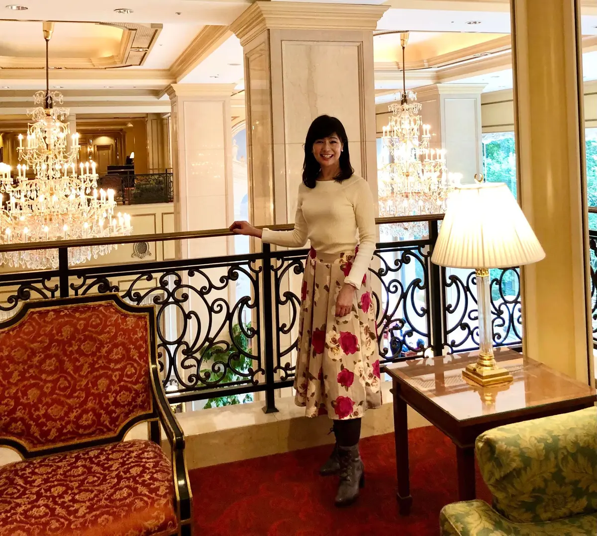 白いニット＆花柄フレアスカート。グレーのタイツ＆ブーツ。