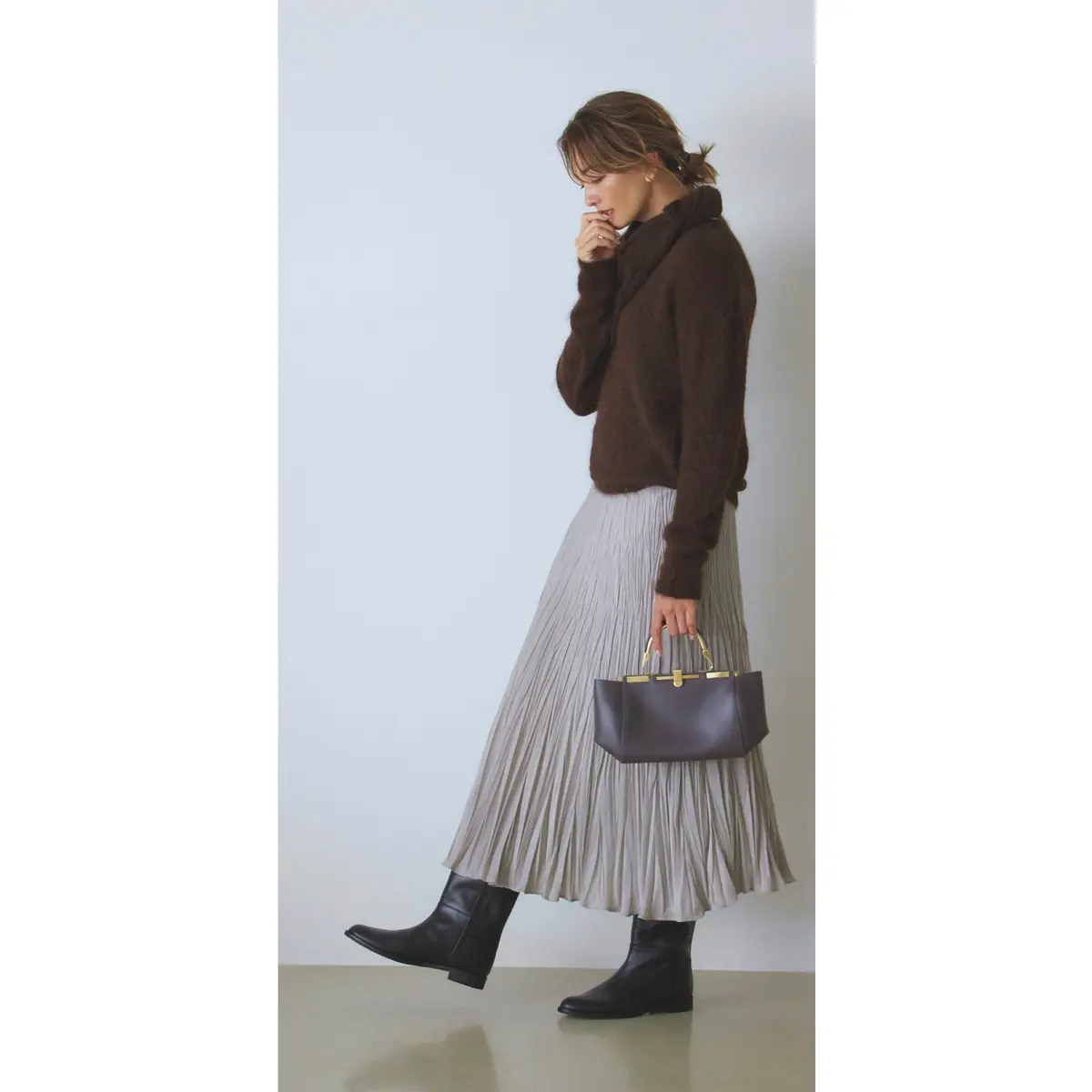 ブラウンのオフタートルニットとグレーのプリーツスカートのコーデ　モデル・RINA
