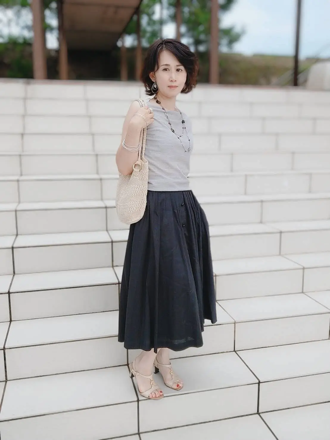 天然石のロングネックレスや細いシルバーのブレスレットを重ねました。イヤリングは大きめで揺れるタイプ。指にはシルバーとシェルのコンビのリングを。