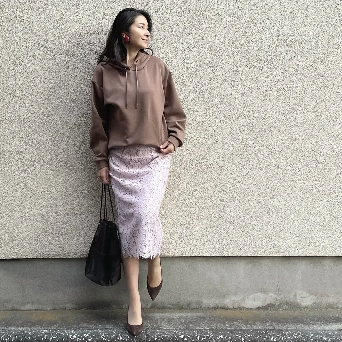 オレンジ系ブラウンのパーカー、ピンクのレーススカート、ブラウンのバッグ、ブラウンのパンプス