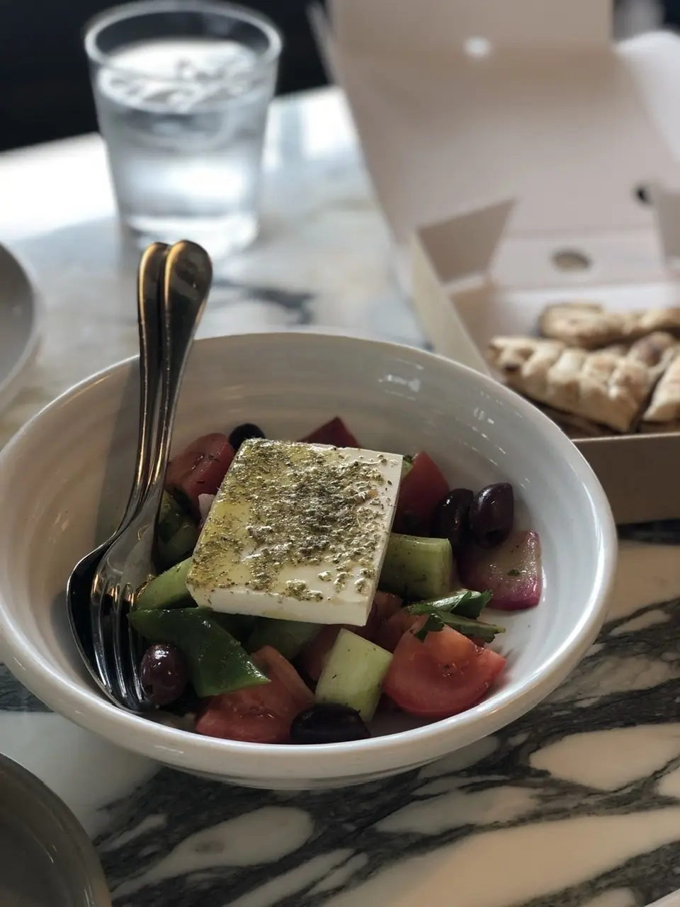 オリーブ、トマト、きゅうりのフレッシュサラダに、なめらかで濃厚で塩気の効いたフェタチーズをのせたサラダ