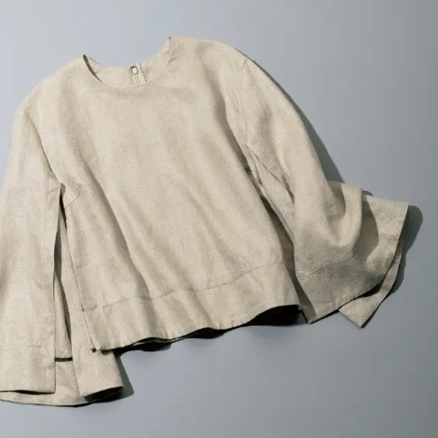 袖の内側に入ったスリットが絶妙な抜け感を演出するベージュトップス