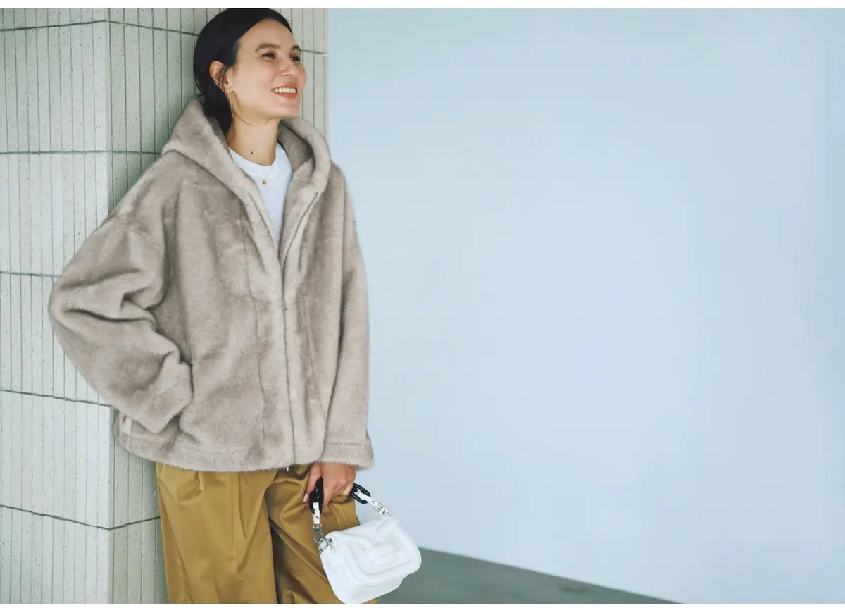 ベージュのフェイクファーフードコートにキャメルのパンツを合わせたグラデ配色のコーディネート　モデル・田沢美亜　