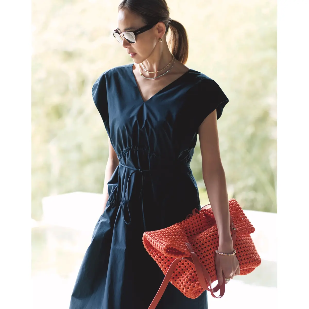 ネイビーワンピースにオレンジのメッシュ編みバッグを合わせたコーディネート　モデル・SHIHO