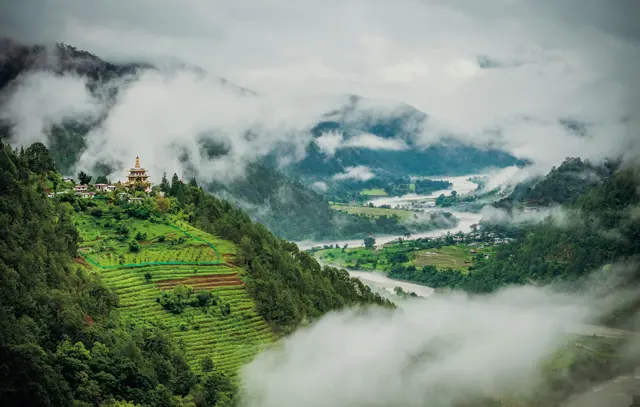 険しい山々が続くブータンでは、名もなき絶景がいくつも見つかる。早朝のプナカ渓谷を流れる雲は、まるで龍のよう。丘の上のカムスム・ユーレイ・ナムギャル・チョルテンは、国王の母堂が世界平和を願って建設した塔